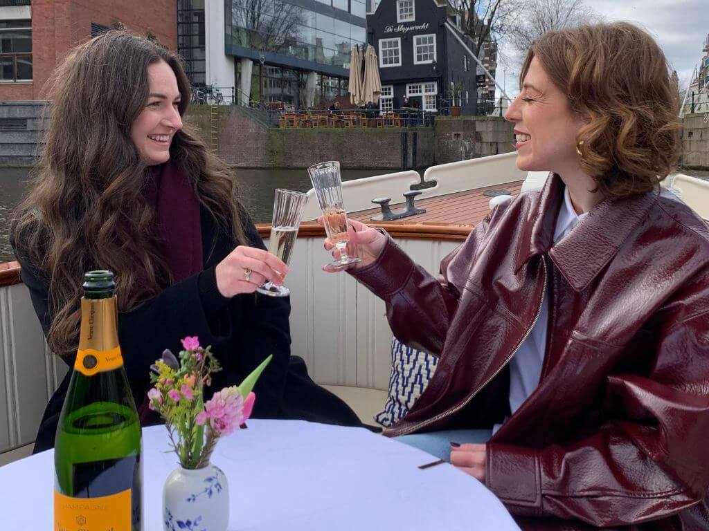 Tourists enjoying a brunch tour and drinks on an Amsterdam canal boat
